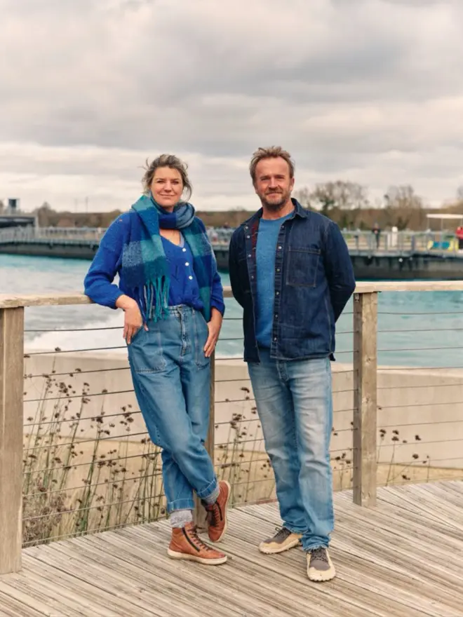 Man and woman standing on decking by water