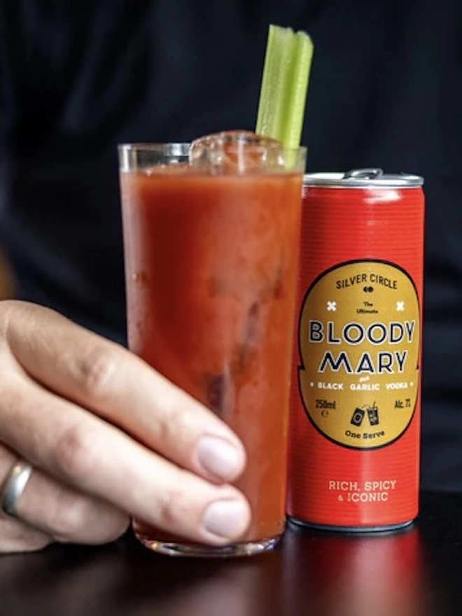 The Holiday Essentials Bundle (Pack Of 7), can of bloody mary next to a glass of bloody mary. 