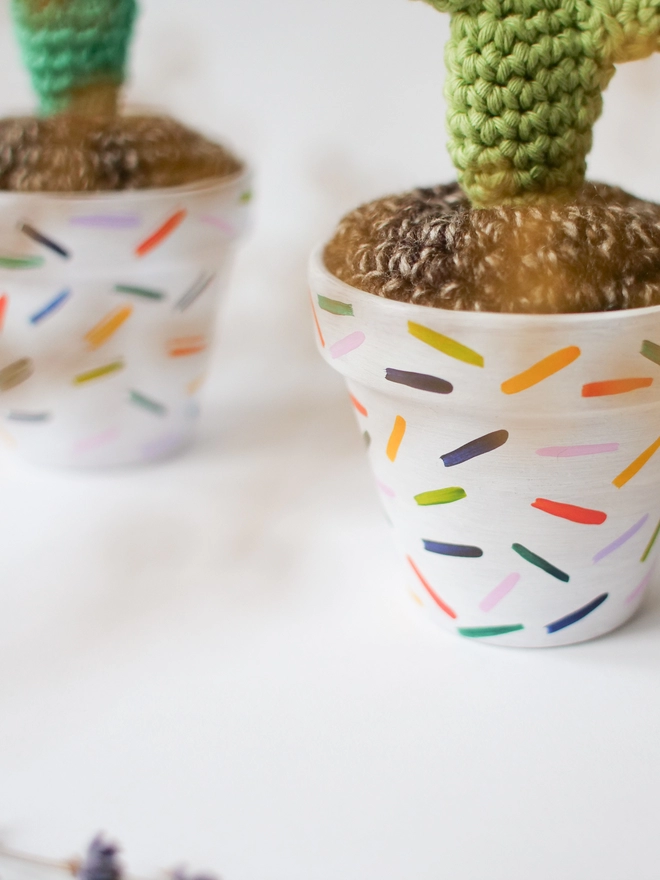 Close up of crocheted colourful hand-painted pot