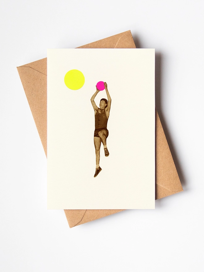 A greeting card depicting a male basketball player throwing a pink ball into the hoop.