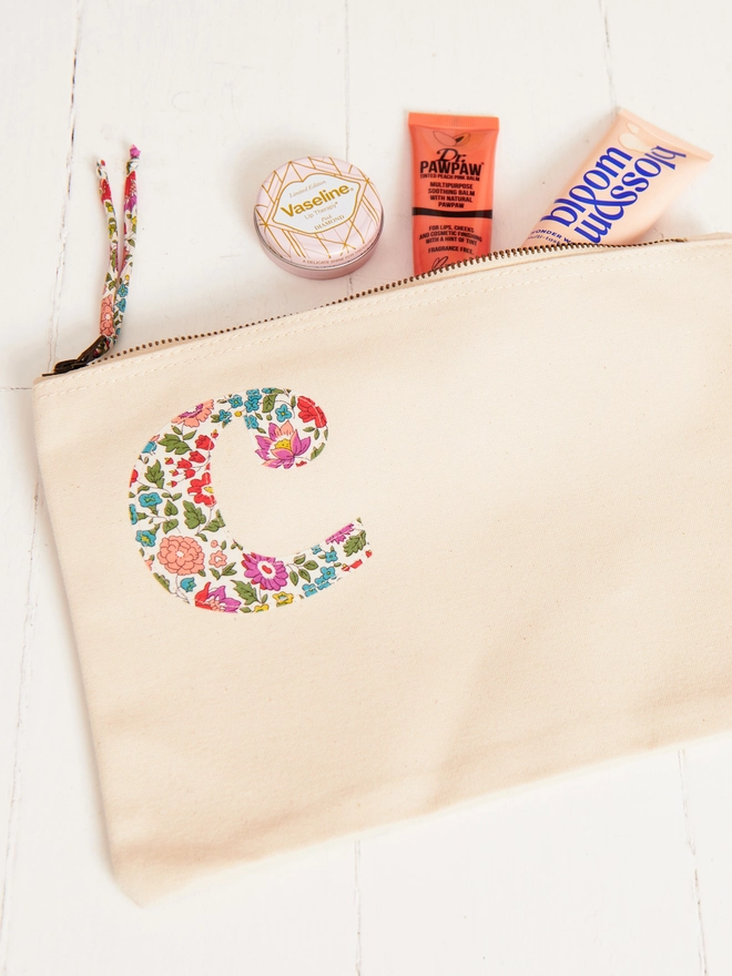 a natural make up zip up pouch personalised with a liberty print initial on the front in the corner