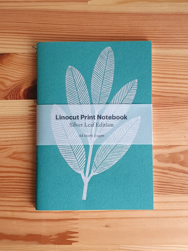 Green notebook with linocut sliver leaf on the cover