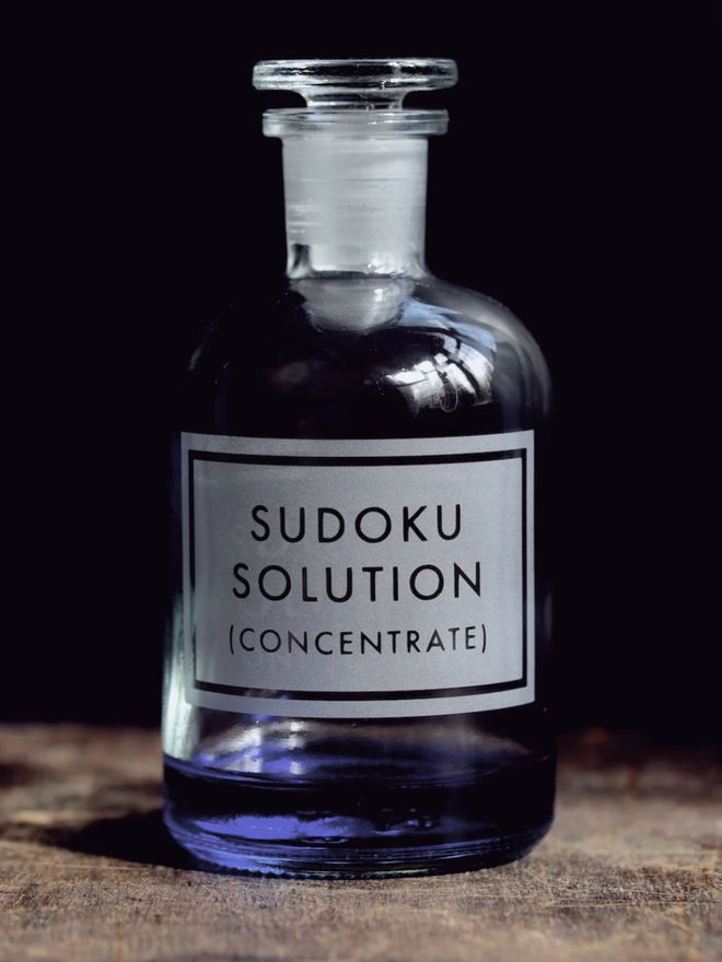 Sudoku Solution Concentrate bottle. A bottle of blue liquid with a stopper, labelled ‘Sudoku Solution (Concentrate)’.