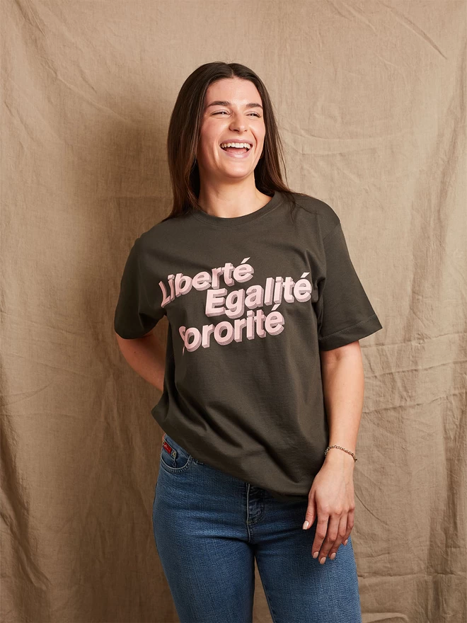 Model is wearing a charcoal grey cotton t-shirt with the slogan Liberté, Egalité, Sororité in pale pink written on the front