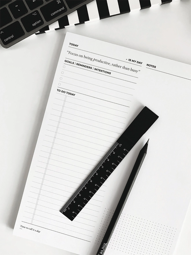 Daily Productivity Desk Pad with a black ruler and pencil laid on top.