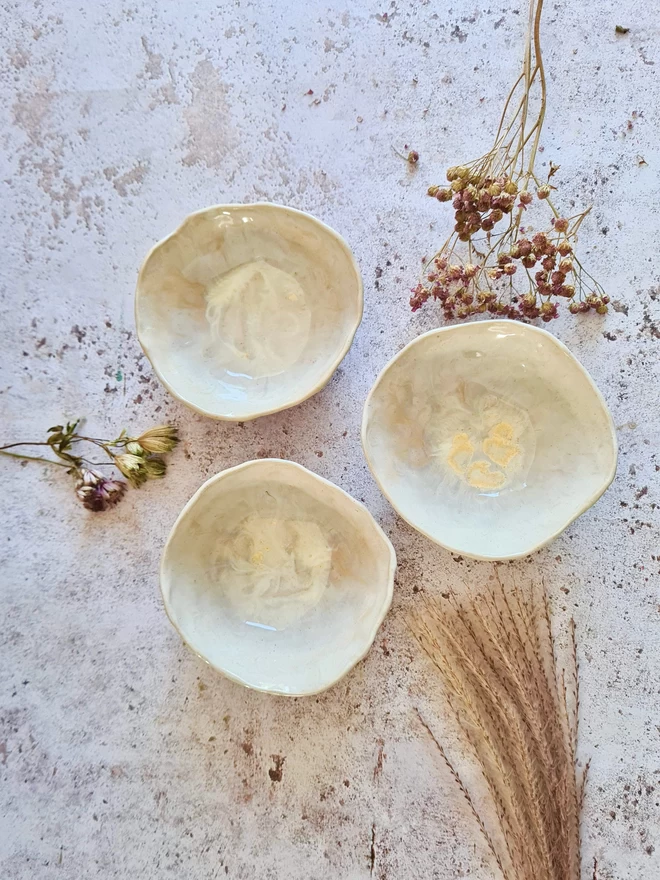 Triple mini ceramic bowls, pottery bowls, gifts, homeware, tableware, dip bowl, snack bowl, small bowl, Jenny Hopps Pottery, Dream Catcher, white cream, neutrals, photographed with dried flowers, cherries on a mottled white background