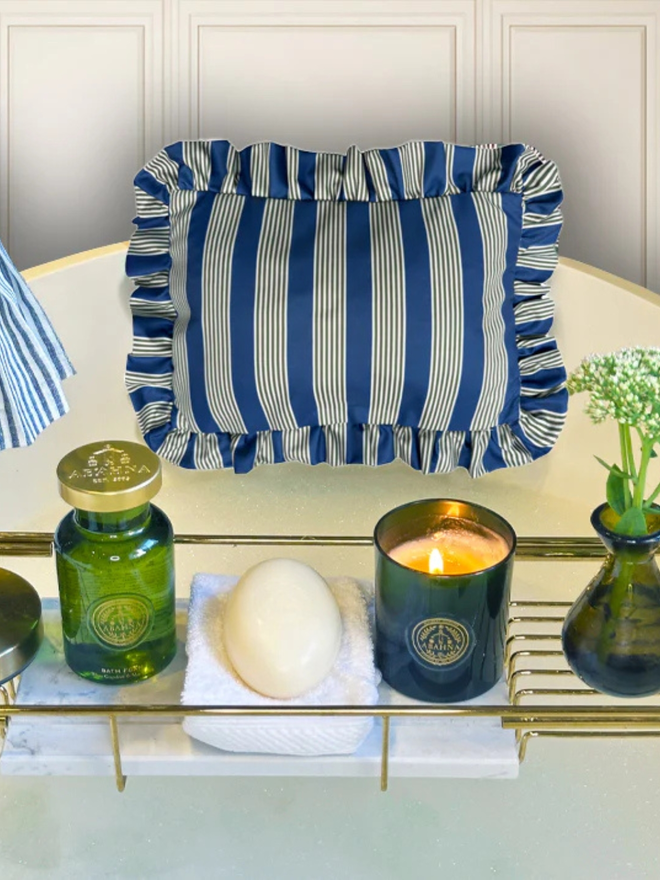 luxury frilled bath pillow. a blue and green striped frilled bath pillow affixed to a bath with candles.