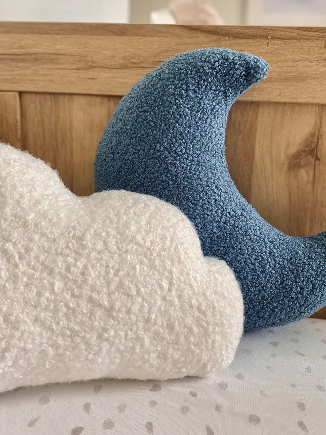 boucle moon and cloud pillow set. a white cloud and blue moon cushion on a sofa.