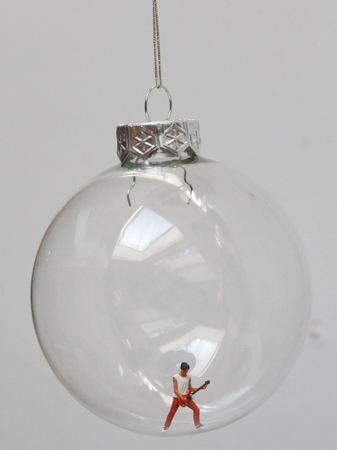 Miniature figure of a male electric guitarist in a glass hanging christmas bauble 