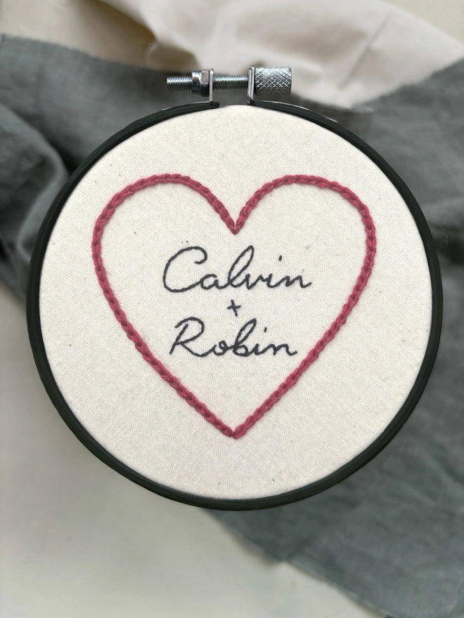 Calvin and Robin hand embroidery in wooden hoop red cotton onto calico cursive handwriting
