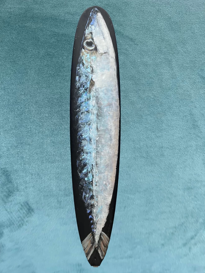 big mackerel painted repurposed surfboard shown against a coloured background
