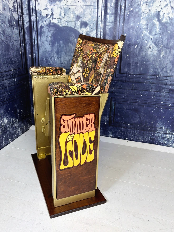 Refurbished vintage cinema seat upholstered in Summer of Love velvet.  The cinema seat is side on showing off the songwriting saying Summer of Love  The cinema seat has gold legs.