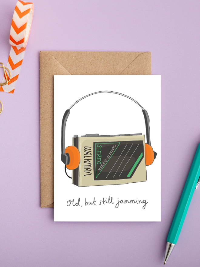 Retro birthday card with an illustrated Walkman cassette player and headphones, caption reads ‘Old, but still jamming’