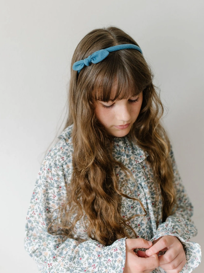 Girl in blue floral dress and Indigo blue alice band