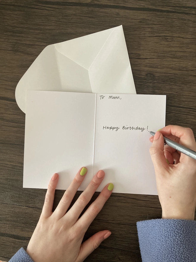 Hand writing birthday message inside greetings card