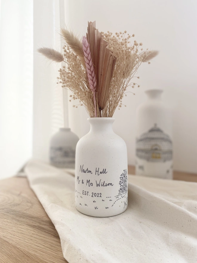 The back of a ceramic vase with black hand written personalisation  