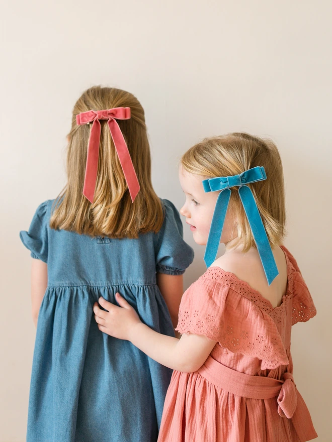 Two girls in their velvet hair bows and dresses