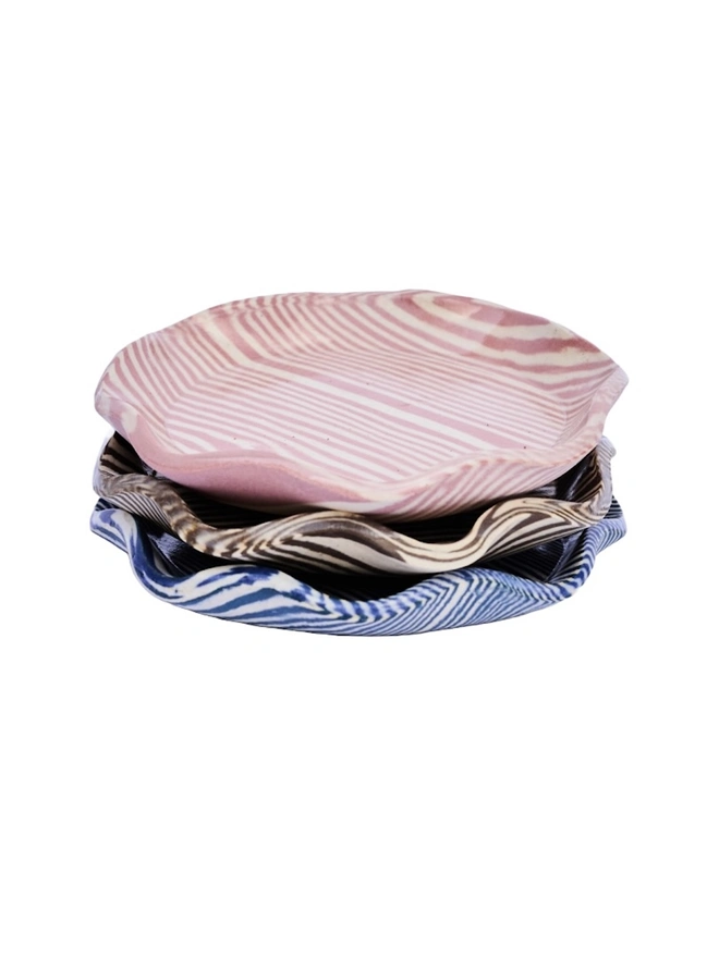 Striped Trinket Dish, a group of colourful trinket dishes sitting on a white surface against a plain backdrop. 