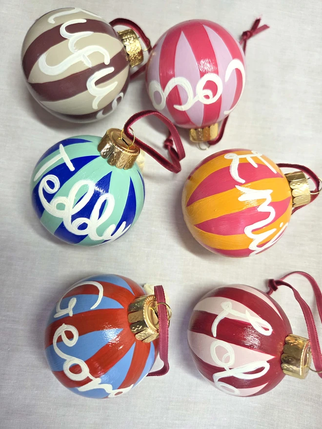 Hand painted christmas baubles in bright stripes with name personalisation 