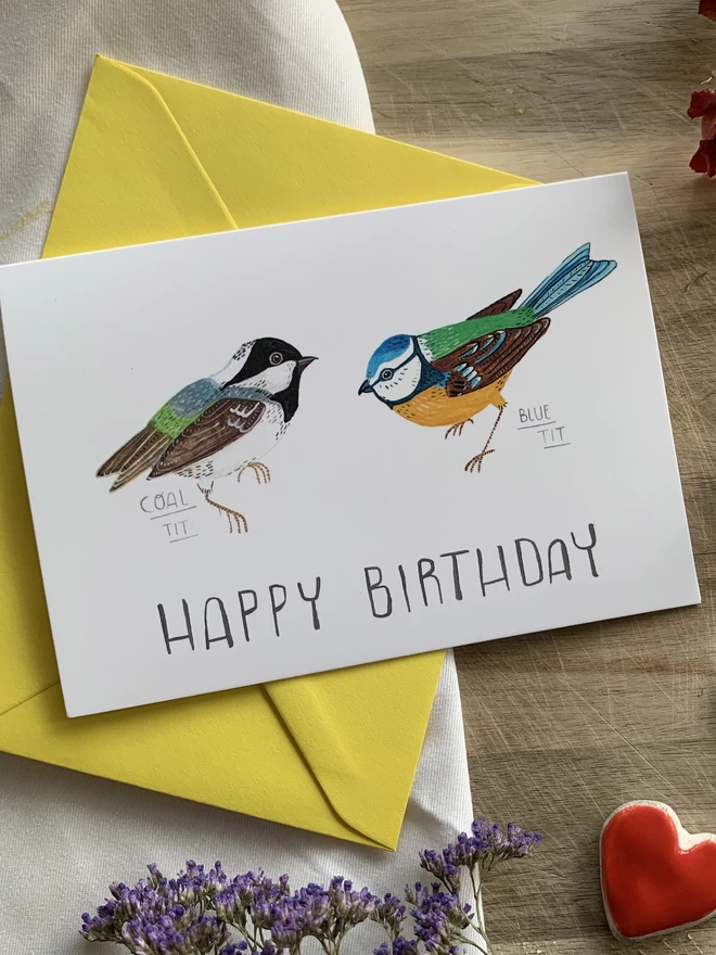 A pair of illustrated tit birds, one blue tit and on coal tit side by side on the front of an A6 greeting card that reads Happy birthday 