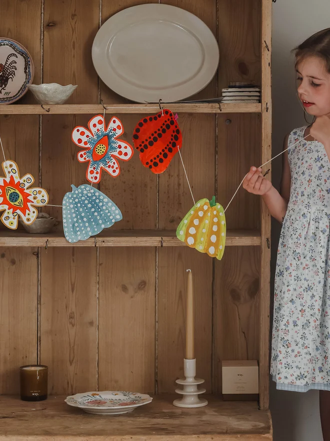 Art project for children inspired by artists to create a garland of spotty pumpkins