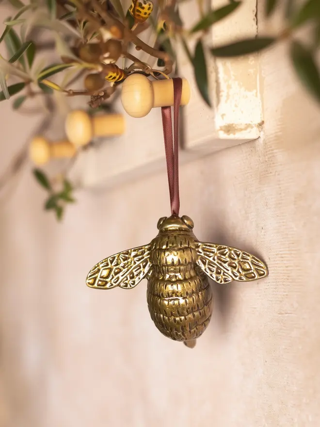 Bee metal hanging decoration hanging from wooden peg