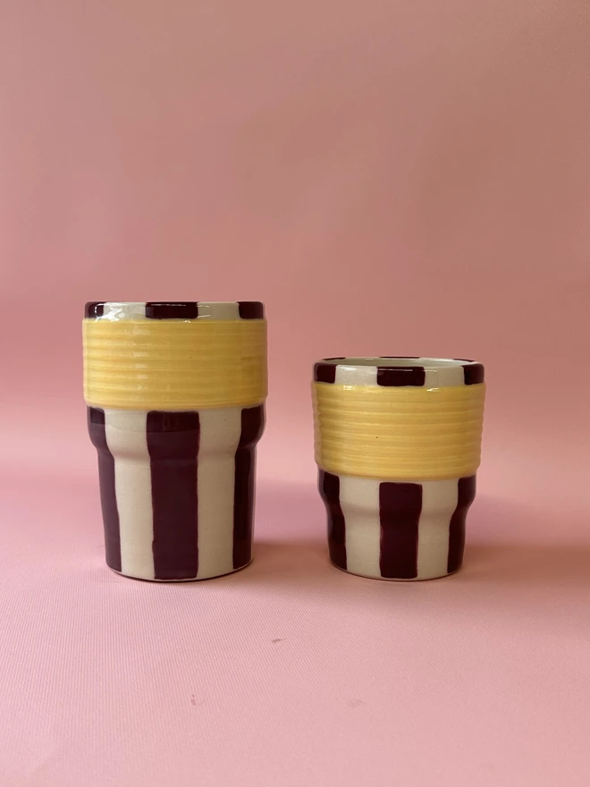     Large and small burgundy and yellow striped ceramic tumblers