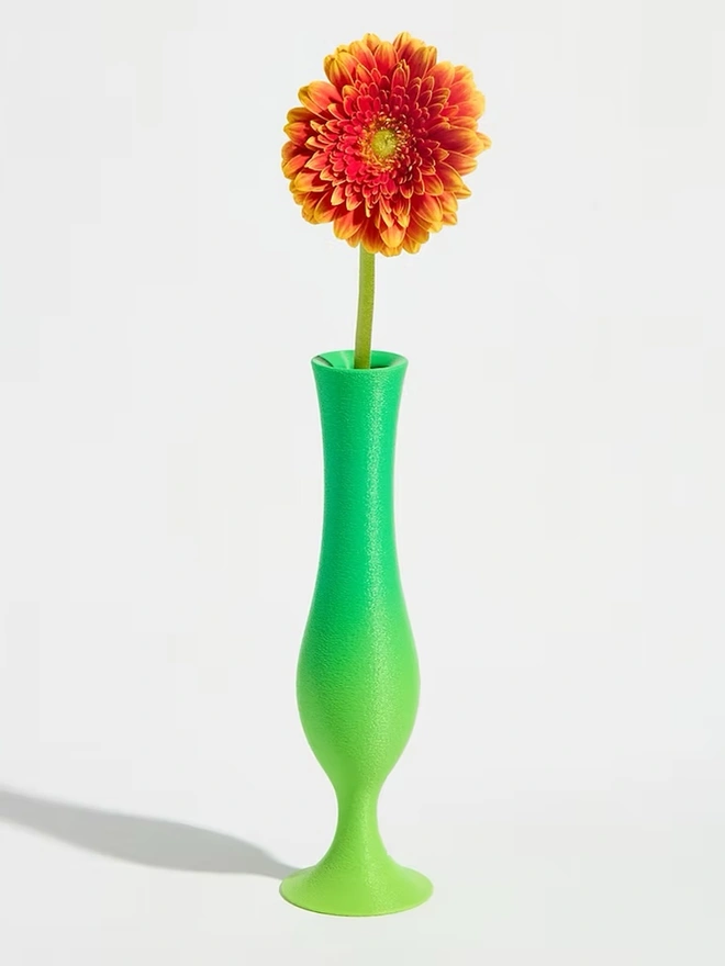 3d printed vase in green stripes with bright pink flower