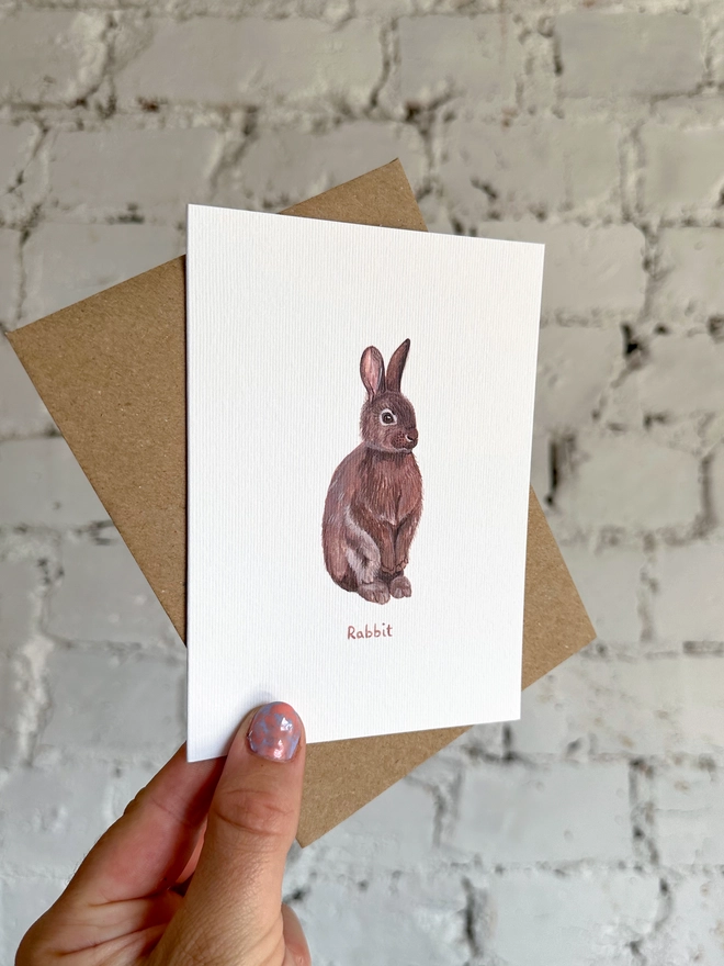 A greetings card featuring an illustrated rabbit with a brown kraft envelope