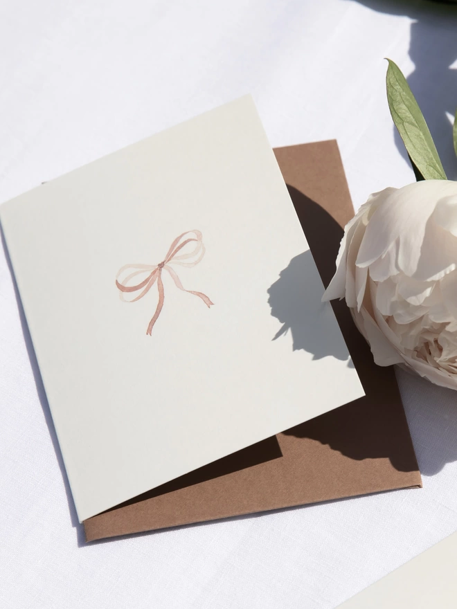 Shell pink bow greetings card with a mid nubuck brown envelope
