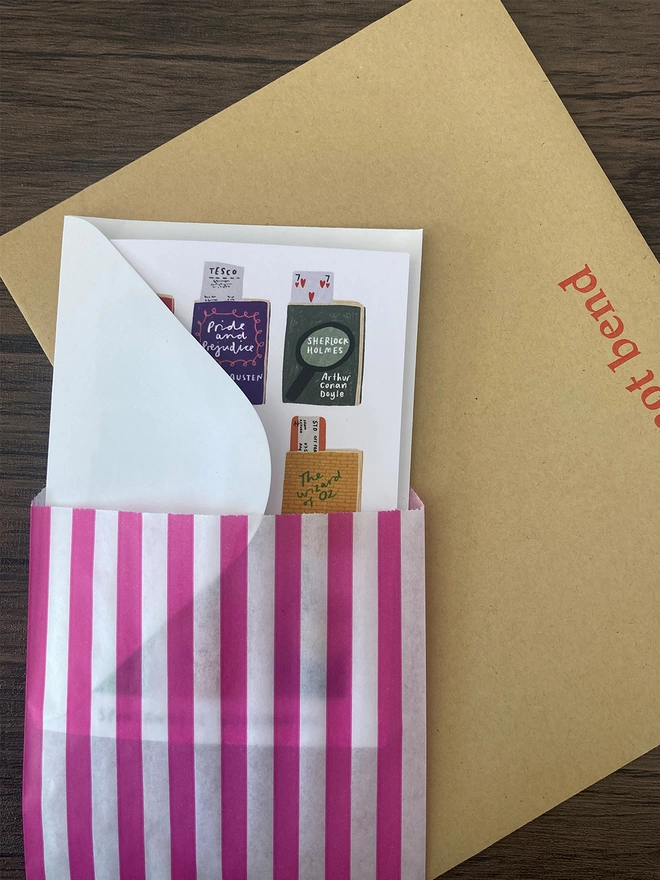 Spontaneous bookmarks card packed with a white envelope inside a paper bag