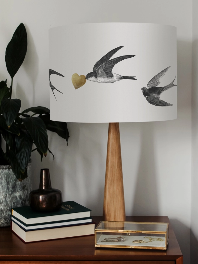 Handmade lampshade featuring graceful flying swallows swooping through a nature-inspired design, adding an elegant touch to any room.