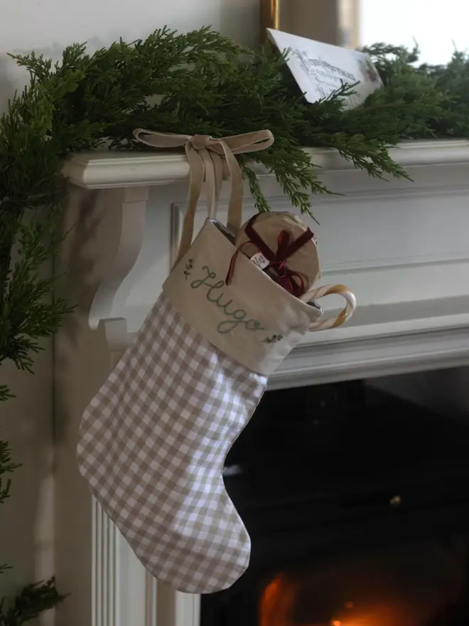 beige gingham stocking with personalised embroidered name hanging
