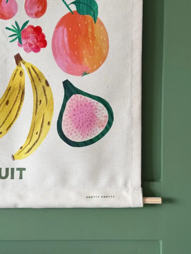 Fruit Print Fabric Banner, hanging on a green wall. 
