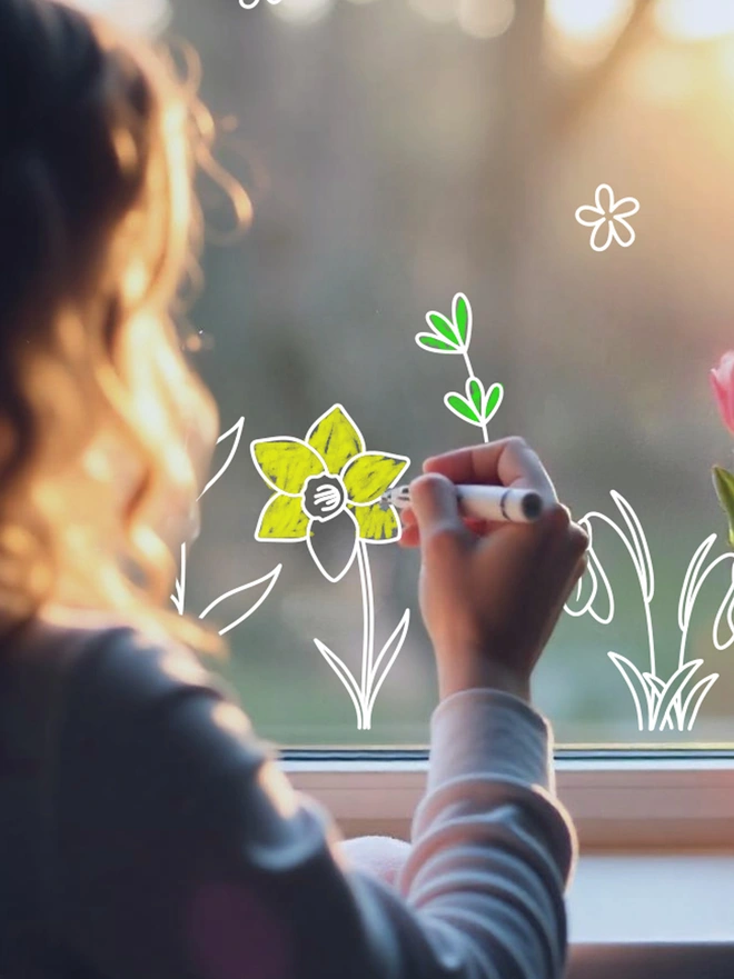 Child colouring in on a window using a colour-in window sticker