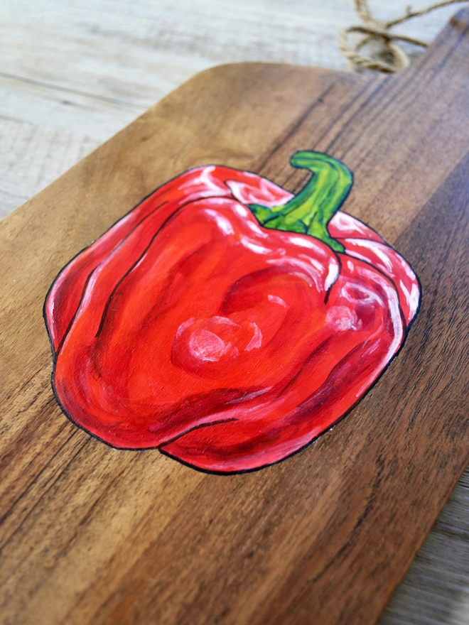 Wooden serving board with handpainted red pepper design