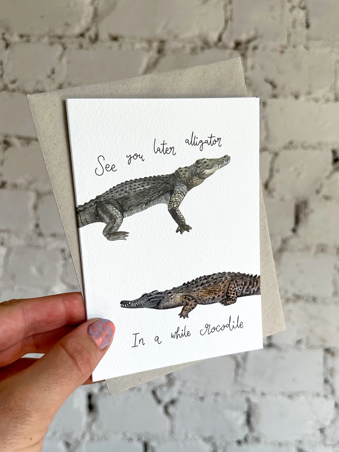 greetings card featuring an illustrated alligator and a crocodile and the phrase “see you later alligator, in a while crocodile”