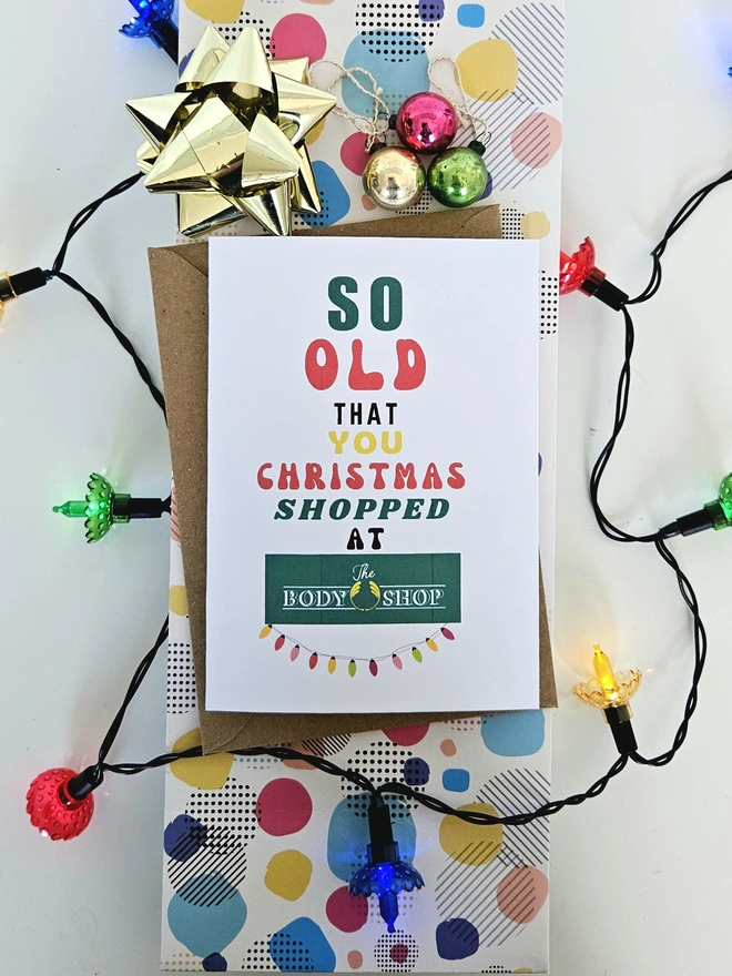 A photograph of the front of a humorous A6 greeting card illustrated using brightly coloured text and the retro shop logo. The text says so old you Christmas shopped at The Body Shop