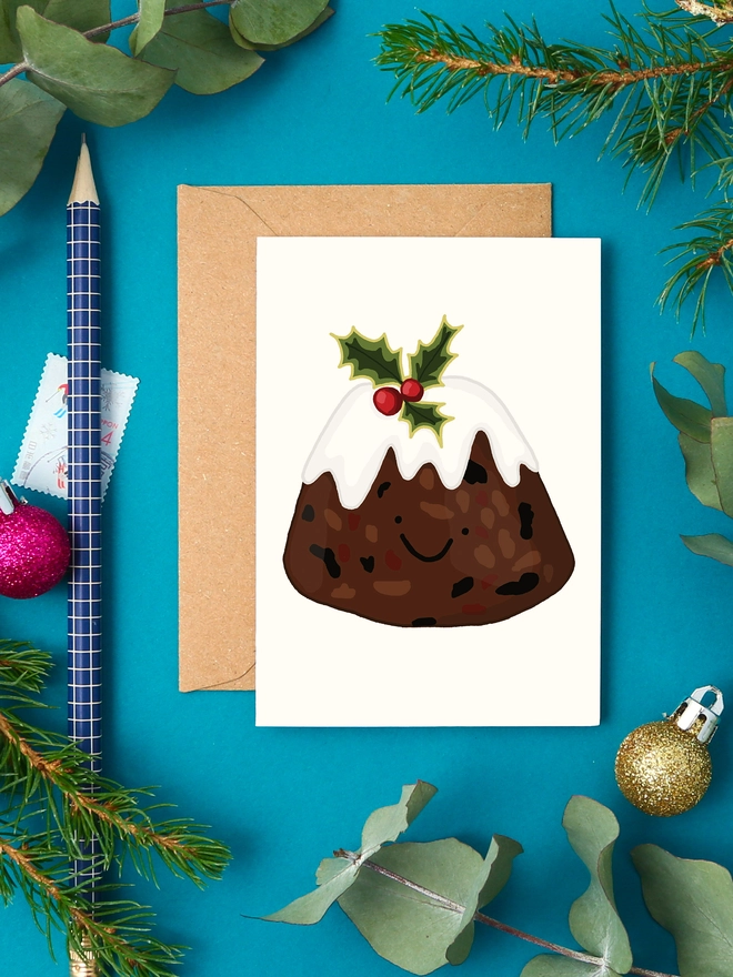 Cute mini Christmas card with illustrated Christmas pudding topped with holly and a happy face