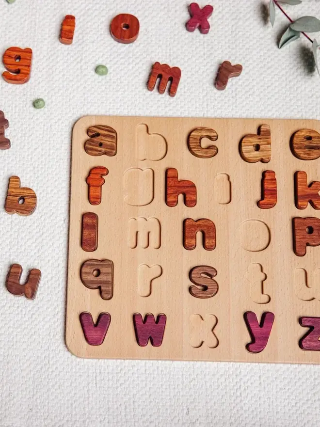 Wood Alphabet Puzzle Heirloom Toy, on a white table. 