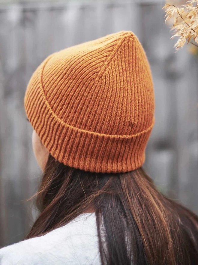 Ribbed Lambswool Women's Beanie, a woman wearing a colourful beanie outdoors. 