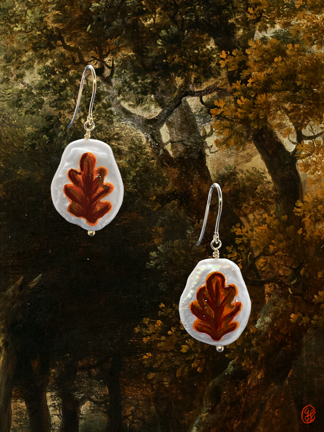 A pair of flat pear shaped pearl earrings with hand painted autumn oak leaf motifs. Set in 9ct gold