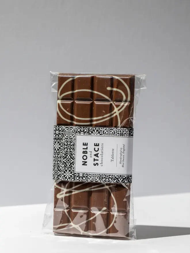 Popping candy chocolate tablette wrapped and standing on a white table. 