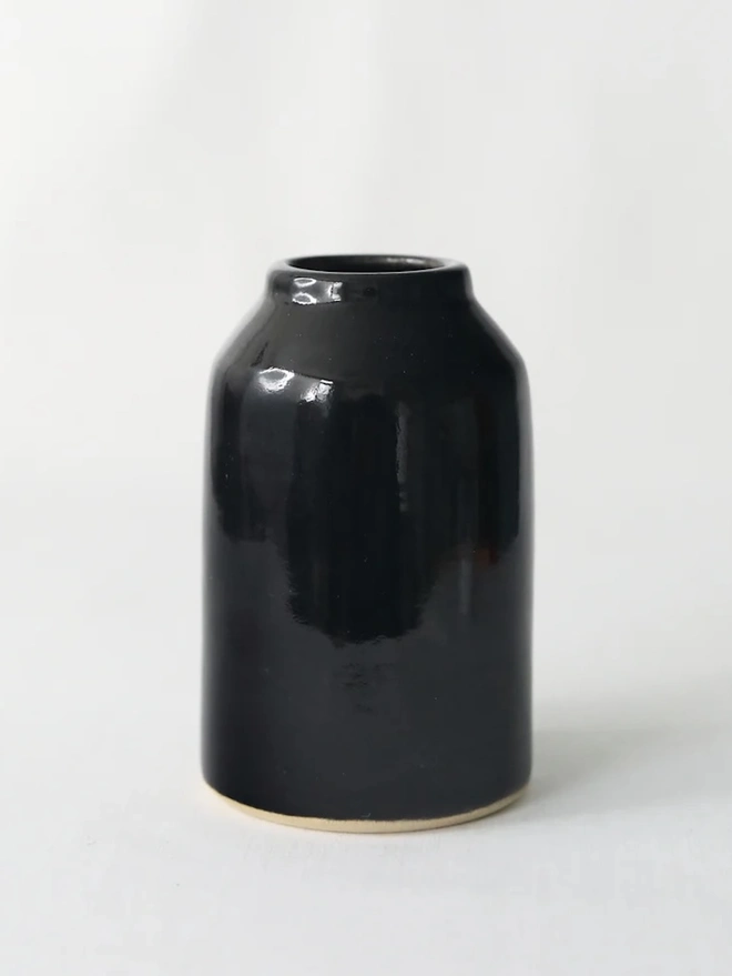 Classic Bud Vase, a colourful ceramic vase sitting on a plain surface against a white backdrop. 