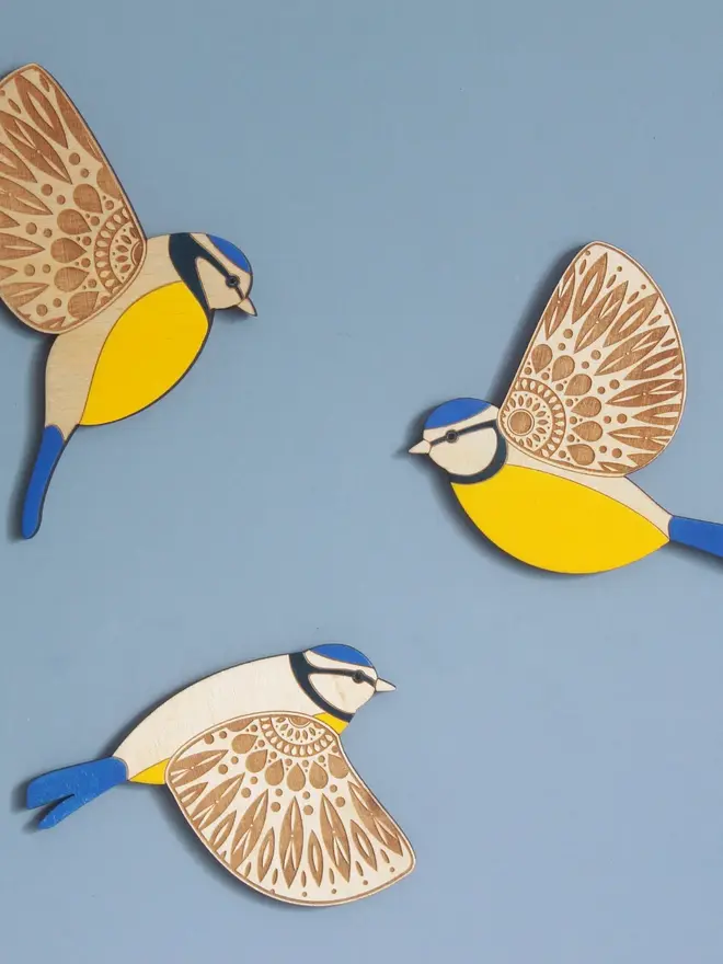 Folk Art Wooden Blue Tits (Set Of 3), wooden blue tits hung up on a wall, flying. 