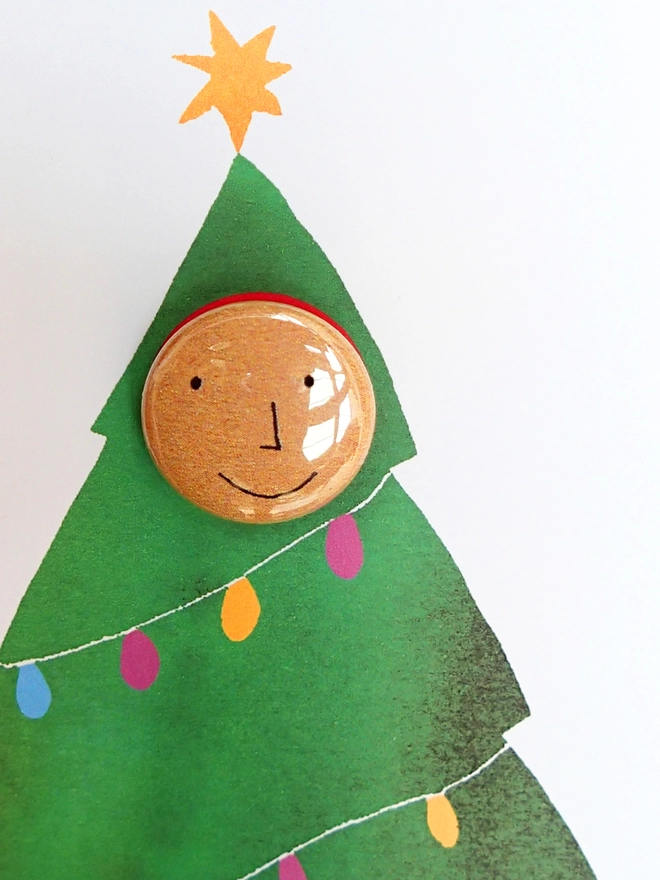 detail of christmas pin badge on the tree costume card