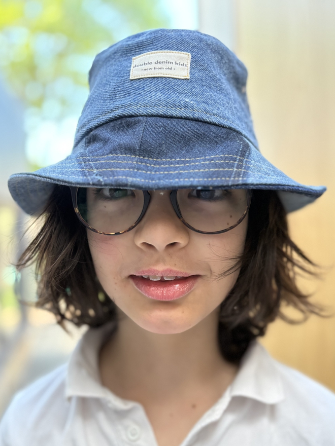 Handmade kids’ bucket hat sewn from reclaimed denim in assorted blue washes, sustainable and one‑of‑a‑kind