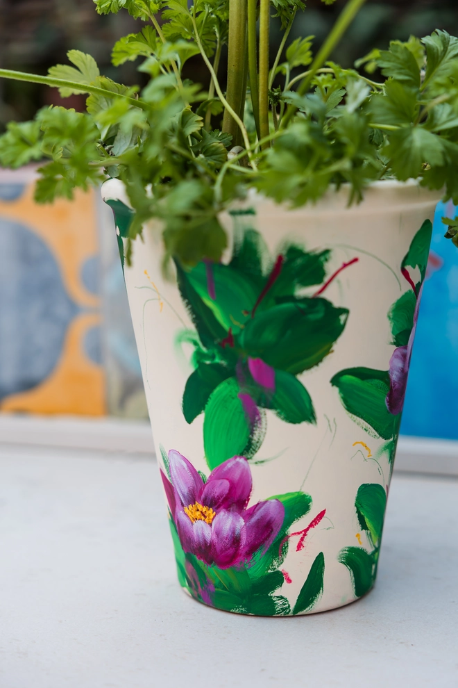 Unique hand-painted terracotta pot featuring pink peony on a cream background