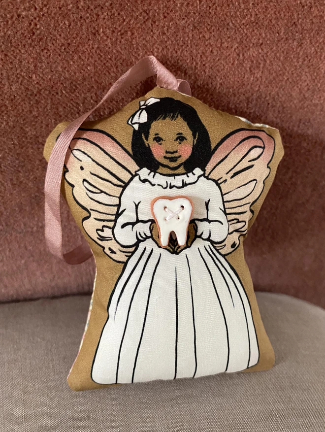 tooth fairy decoration holding a tooth button