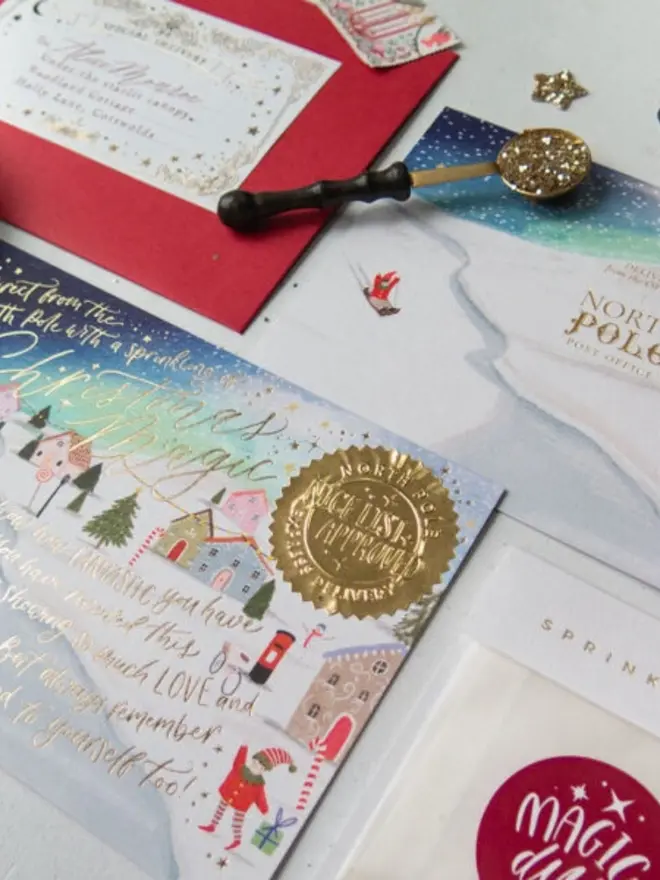 Close-up of gold foil lettering and an embossed "Nice List Approved" seal on the night-sky certificate.